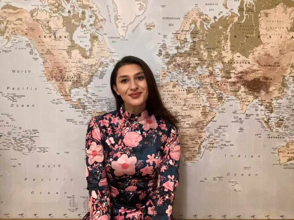 Gizem Albay, persönliche Reiseberaterin aus Bremen, vor einer großen Weltkarte