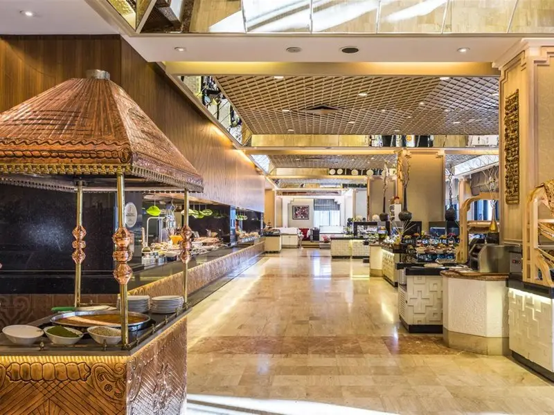 Buffetstationen im Restaurant des Rixos Downtown Antalya mit dekorativer kupferfarbener Überdachung