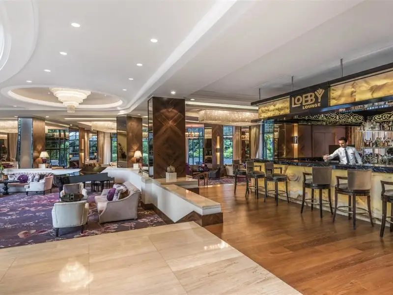 Lounge im Rixos Downtown Antalya mit Sesseln, Tischen und einer langen Bar